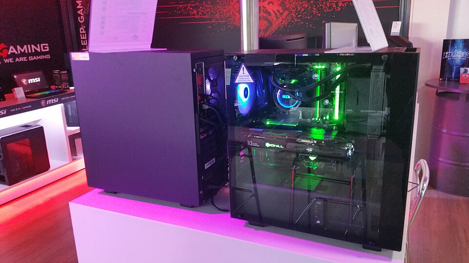Gabinete de un PC de juegos con iluminación y panel transparente, expuesto en una tienda.